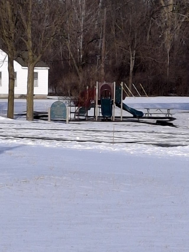 yard layered in snow with a playground