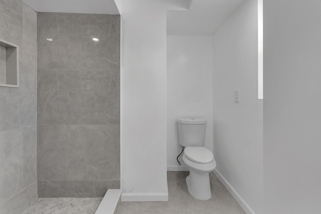 bathroom featuring toilet, tile patterned flooring, and a shower