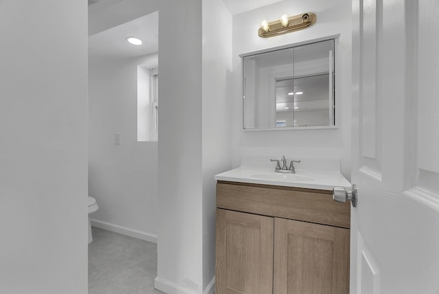 bathroom featuring tile patterned flooring, vanity, and toilet