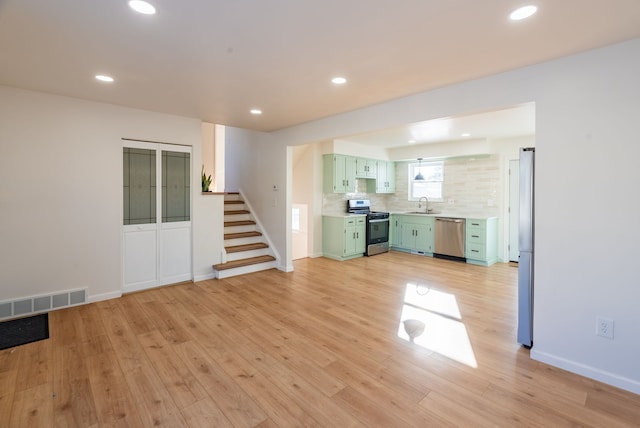 unfurnished living room with sink and light wood-type flooring