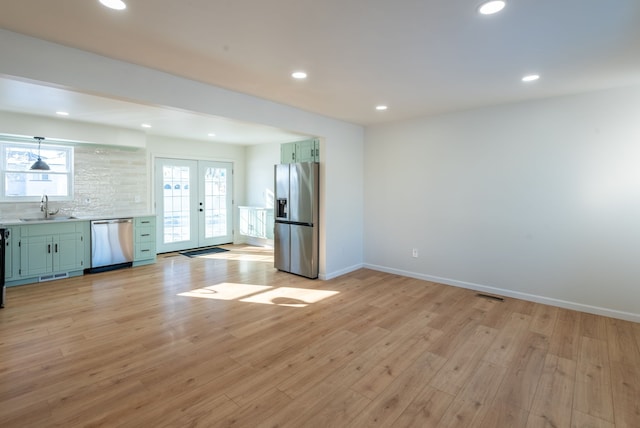 kitchen with sink, stainless steel appliances, light hardwood / wood-style floors, and french doors