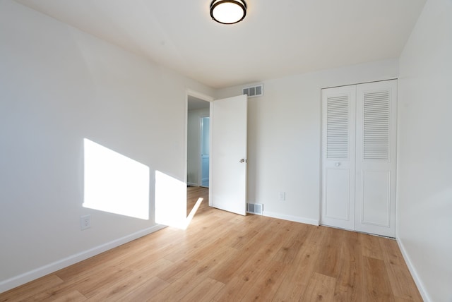 unfurnished bedroom featuring light hardwood / wood-style floors and a closet