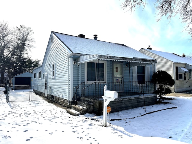 bungalow-style house with a garage and an outbuilding