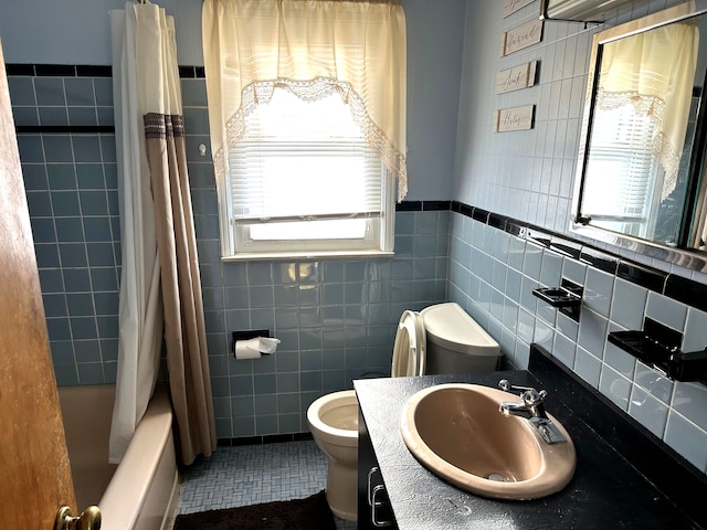 full bathroom with tile walls, tile patterned flooring, toilet, and shower / tub combo with curtain