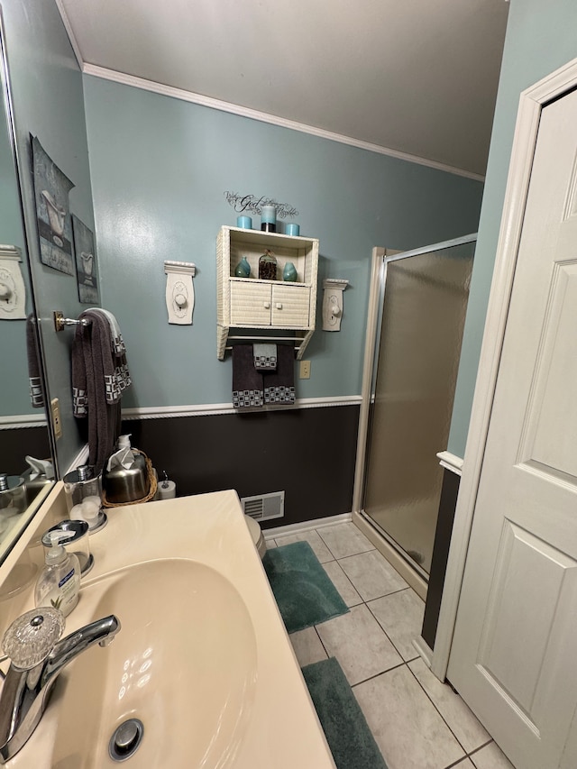 bathroom featuring tile patterned flooring, crown molding, sink, and walk in shower