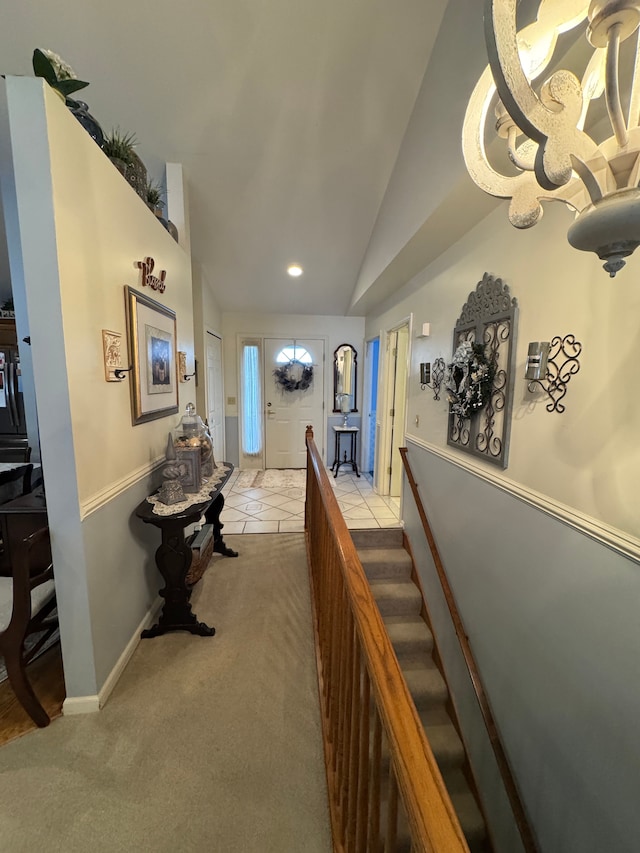 corridor with vaulted ceiling and light carpet