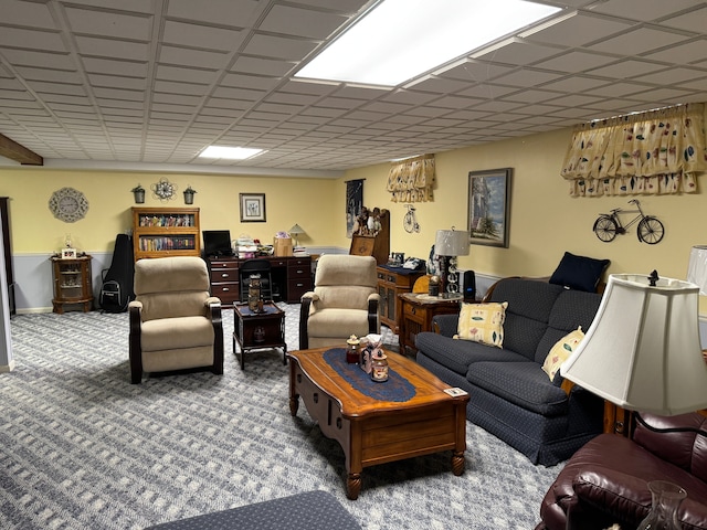 carpeted living room with a drop ceiling