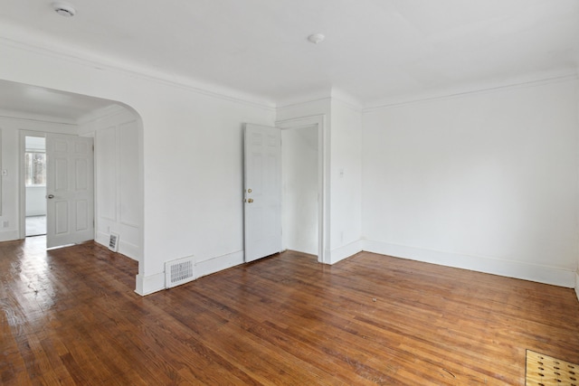 spare room featuring hardwood / wood-style flooring and ornamental molding