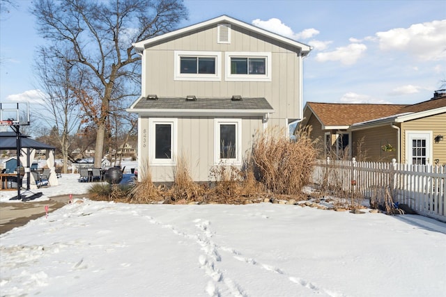 view of snow covered rear of property