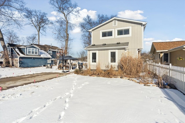 snow covered rear of property featuring a gazebo