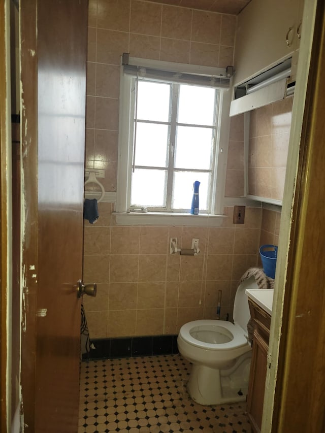 bathroom featuring tile walls, vanity, tile patterned floors, and toilet