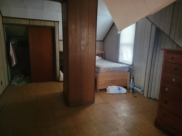 bedroom with a baseboard radiator, lofted ceiling, and wooden walls