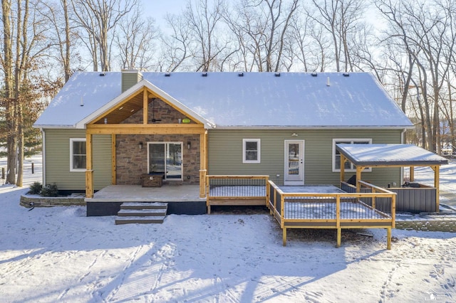 snow covered house featuring a wooden deck