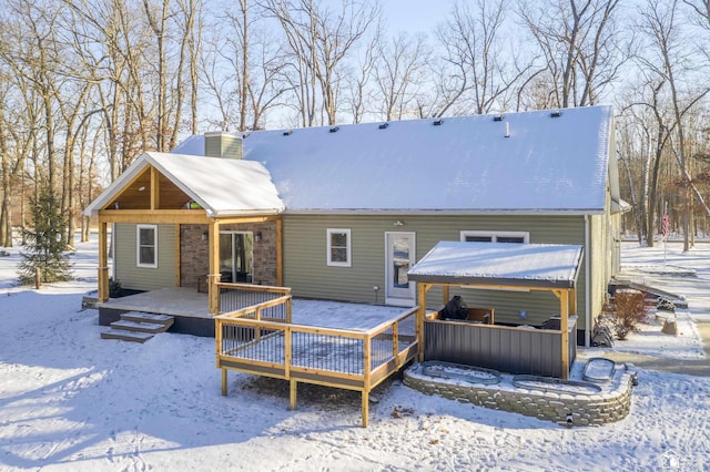 snow covered house featuring a deck