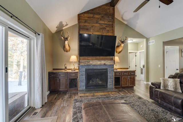 living room featuring dark hardwood / wood-style floors, ceiling fan, a fireplace, and high vaulted ceiling