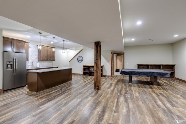 kitchen featuring tasteful backsplash, stainless steel fridge, a kitchen island, pendant lighting, and hardwood / wood-style floors