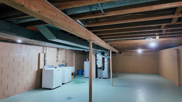 basement with water heater, washing machine and dryer, and heating unit