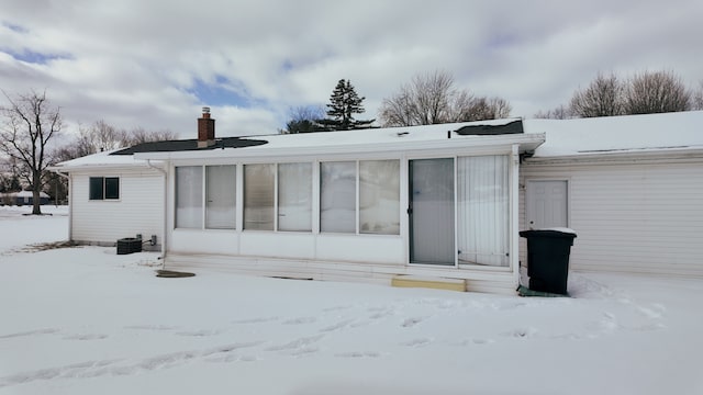 view of snow covered rear of property