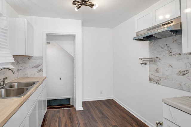 kitchen featuring white cabinetry, dark hardwood / wood-style flooring, sink, and decorative backsplash