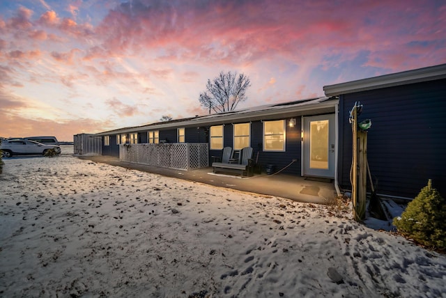 property exterior at dusk featuring a patio