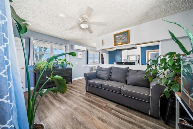 living room with hardwood / wood-style floors, a textured ceiling, a wall mounted AC, and ceiling fan