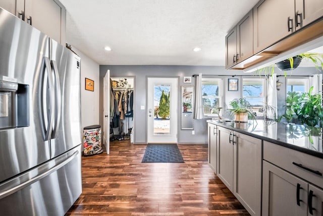 kitchen with stainless steel refrigerator with ice dispenser, dark hardwood / wood-style flooring, a textured ceiling, and gray cabinetry