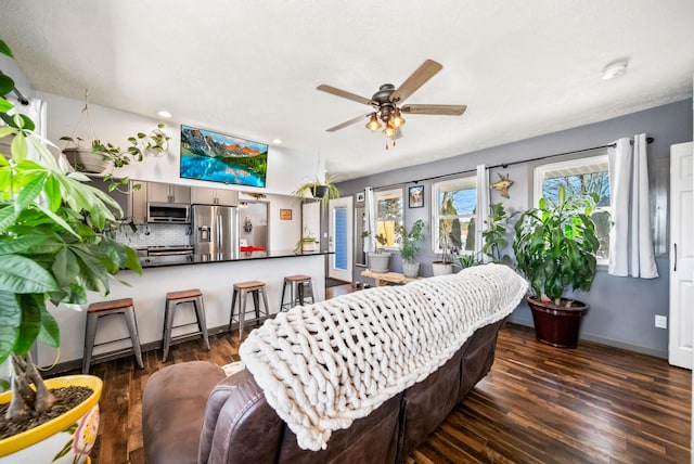 living room featuring dark wood-type flooring and ceiling fan