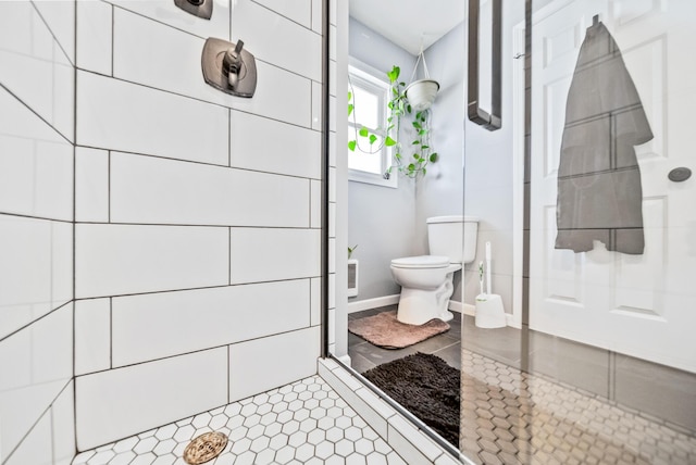 bathroom featuring tile patterned floors, toilet, and a shower