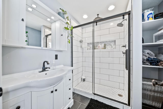 bathroom featuring vanity, tile patterned flooring, and a shower with door