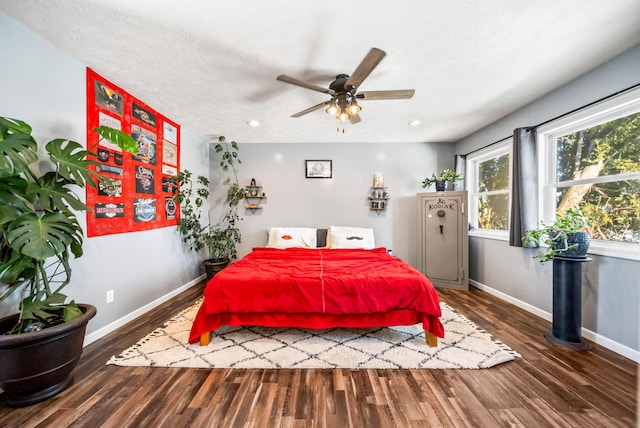 bedroom featuring ceiling fan, dark hardwood / wood-style flooring, and a textured ceiling