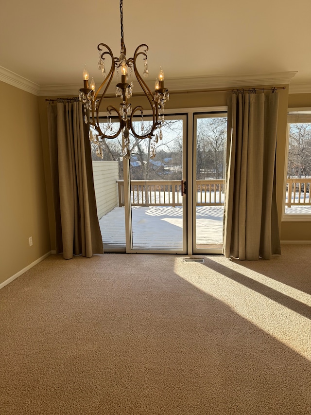 interior space featuring an inviting chandelier, ornamental molding, and carpet flooring