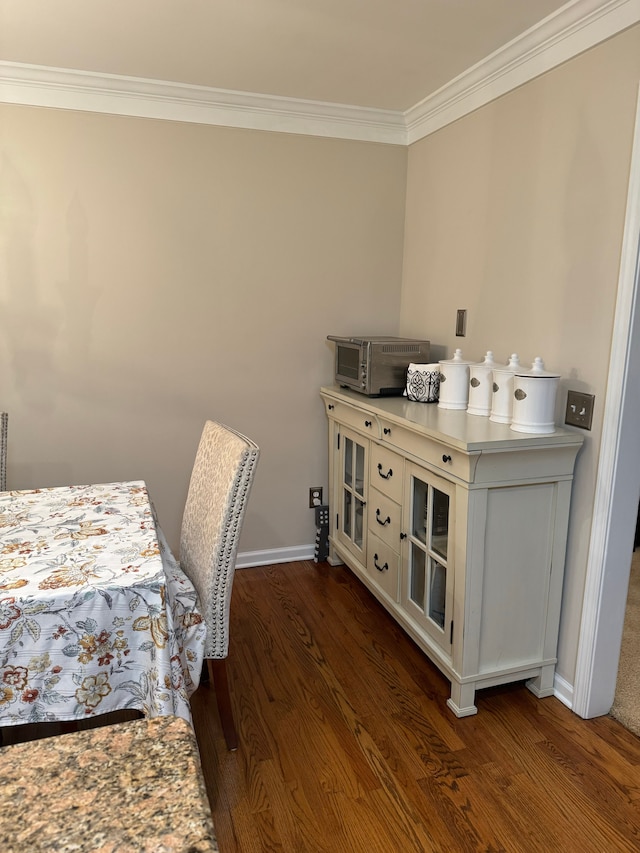 dining area with ornamental molding and dark hardwood / wood-style floors