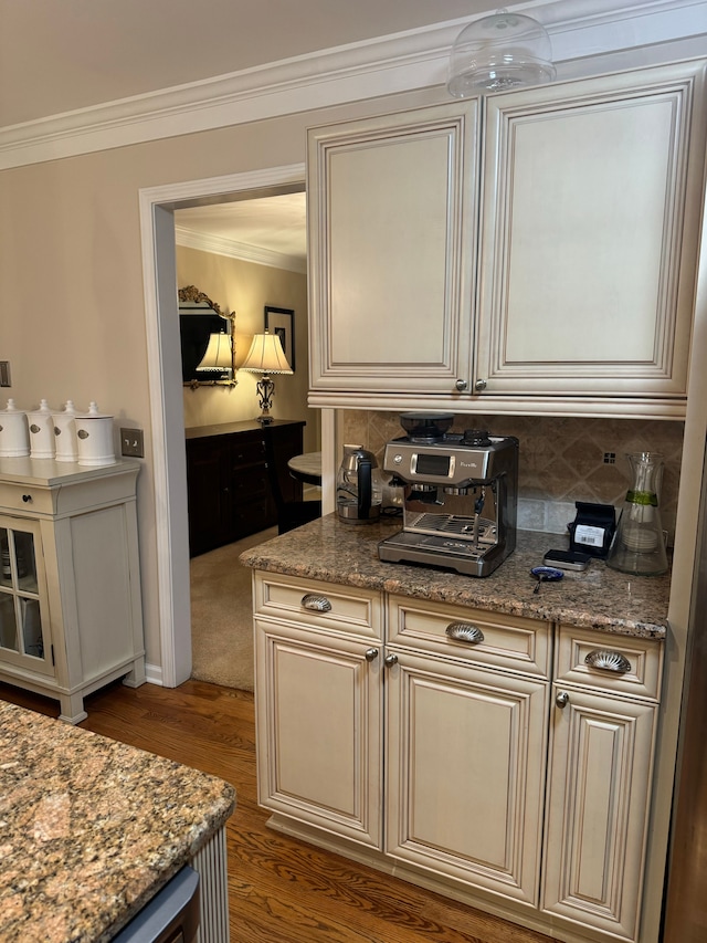 kitchen featuring light stone countertops, backsplash, and cream cabinetry