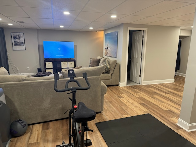 exercise area with a paneled ceiling and light hardwood / wood-style floors