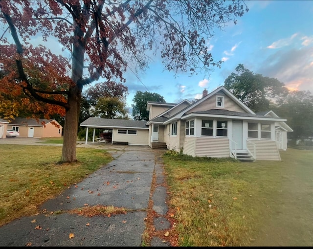 view of front of house featuring a carport and a yard