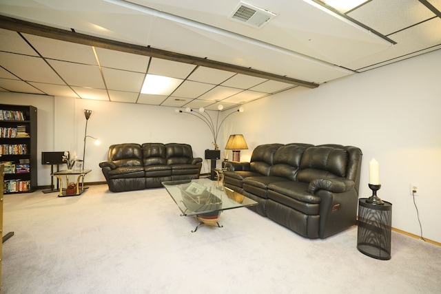 carpeted living room featuring a drop ceiling