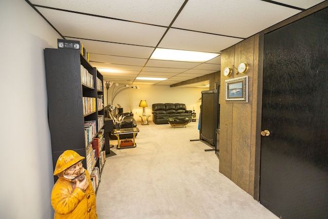 basement with light colored carpet and a drop ceiling