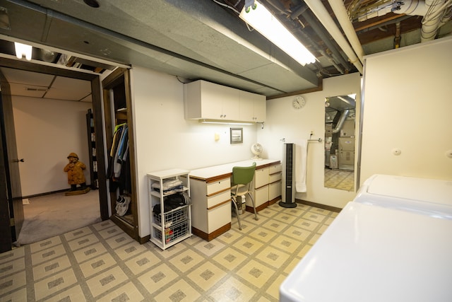 clothes washing area featuring cabinets and washing machine and clothes dryer