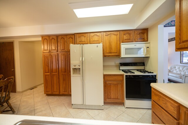 kitchen featuring light tile patterned floors and white appliances