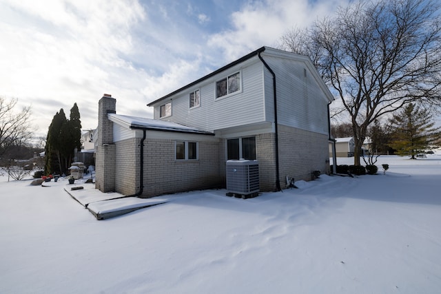 snow covered house with central air condition unit