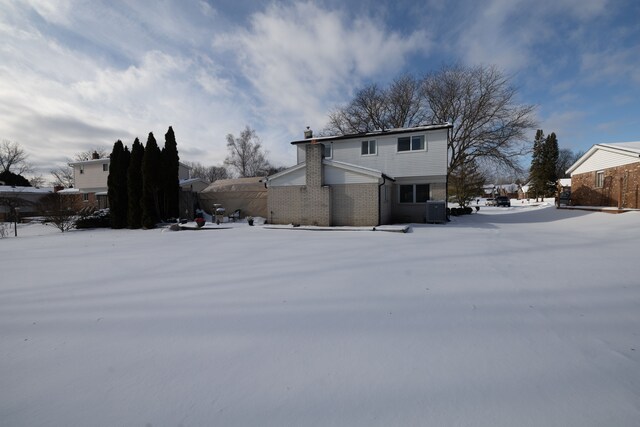 snow covered house with central AC