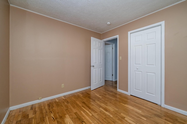 unfurnished bedroom with a closet, light hardwood / wood-style floors, and a textured ceiling