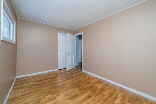 spare room featuring a textured ceiling and light wood-type flooring