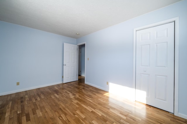 unfurnished bedroom featuring wood-type flooring and a closet