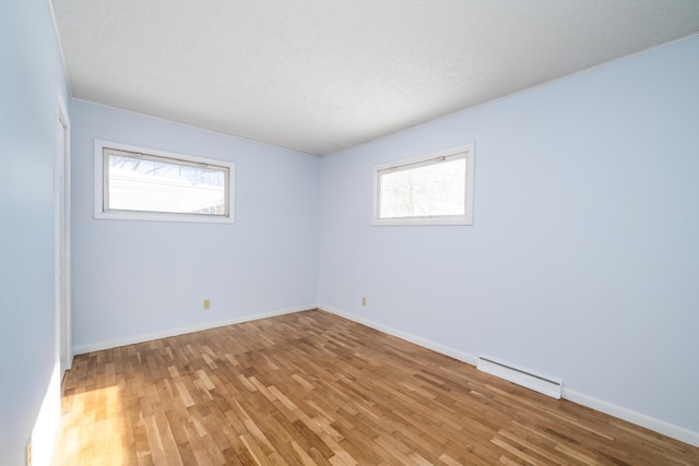 unfurnished room with hardwood / wood-style flooring and a baseboard radiator