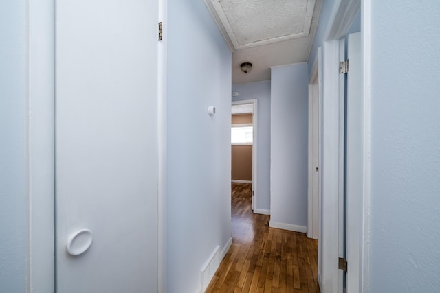 hall featuring hardwood / wood-style flooring and a textured ceiling