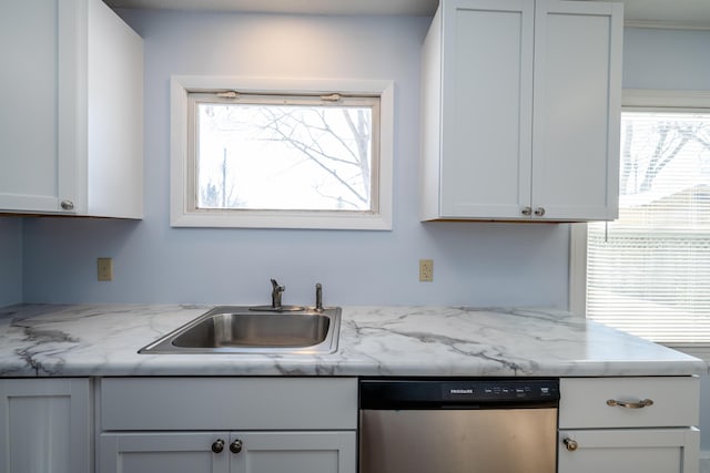 kitchen with white cabinetry, stainless steel dishwasher, light stone countertops, and sink