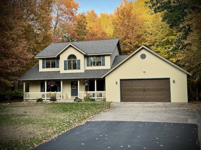 view of front of property featuring a garage, a front yard, and covered porch