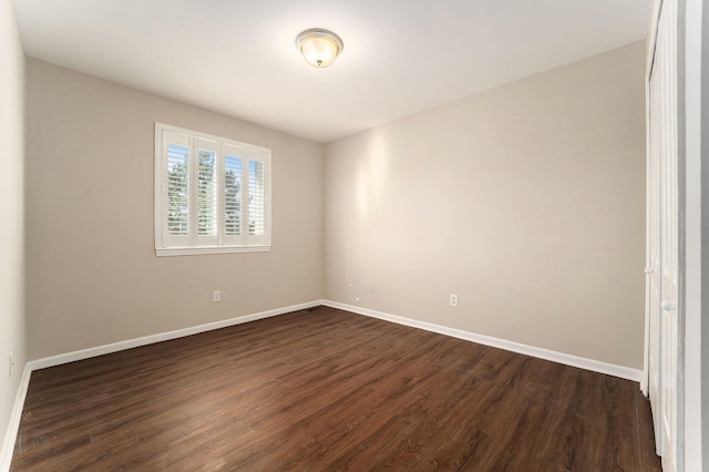 unfurnished room with dark hardwood / wood-style flooring