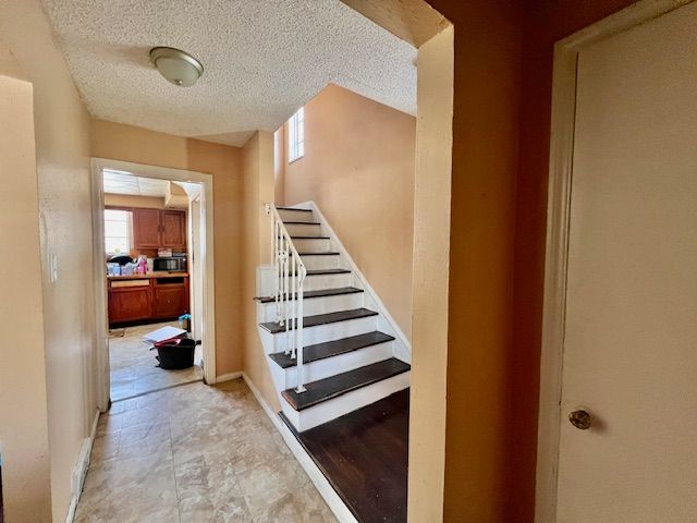 stairs with a textured ceiling